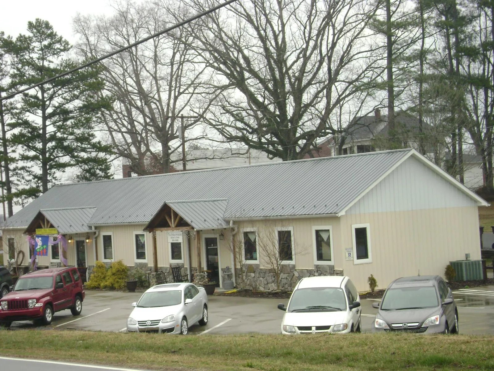 Gray metal roof with timber entry brackets on a small commercial building in Toddville