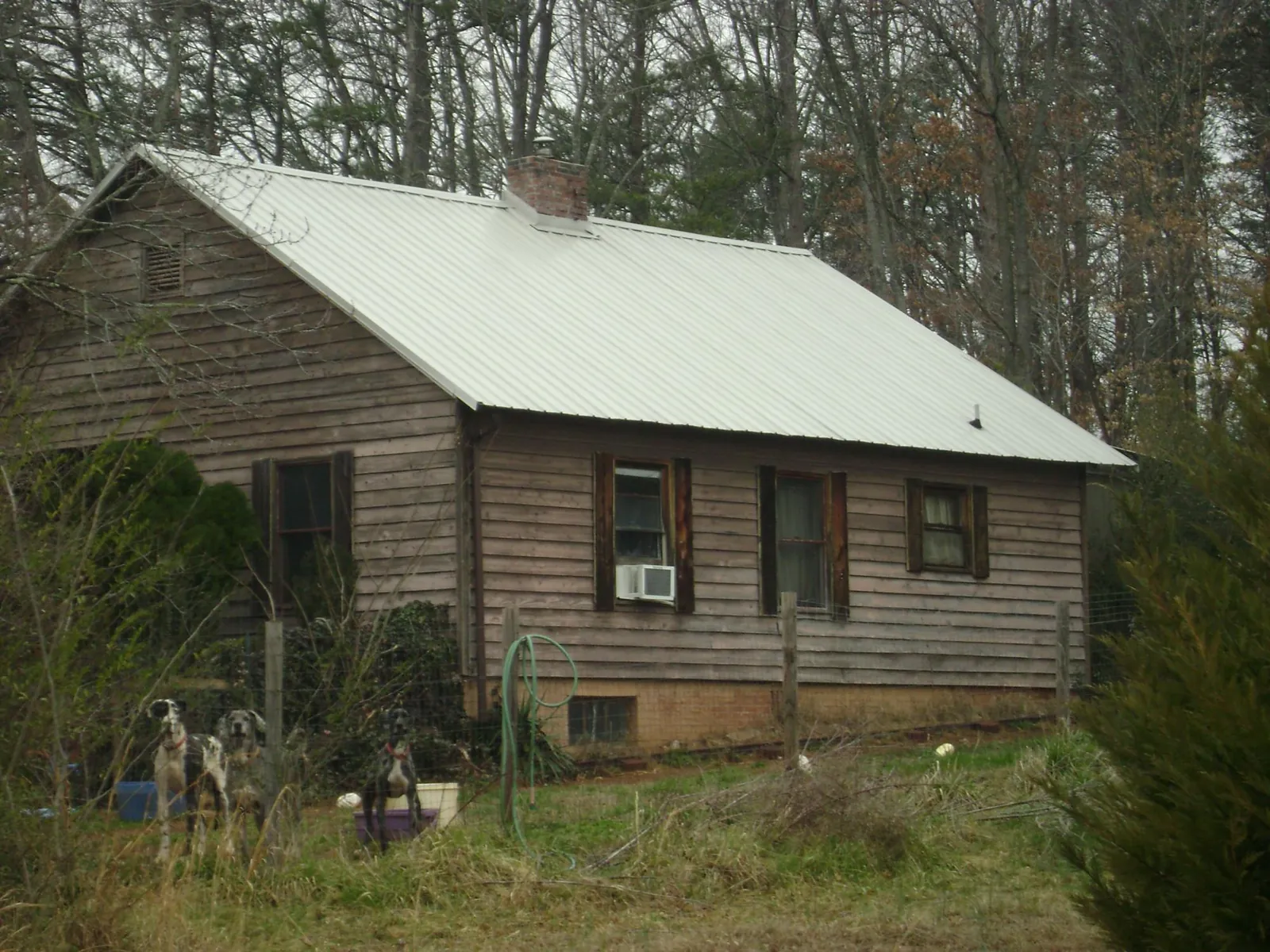White metal roof on an old wood sided farmhouse, from a Metal Roof Installation job in Toddville